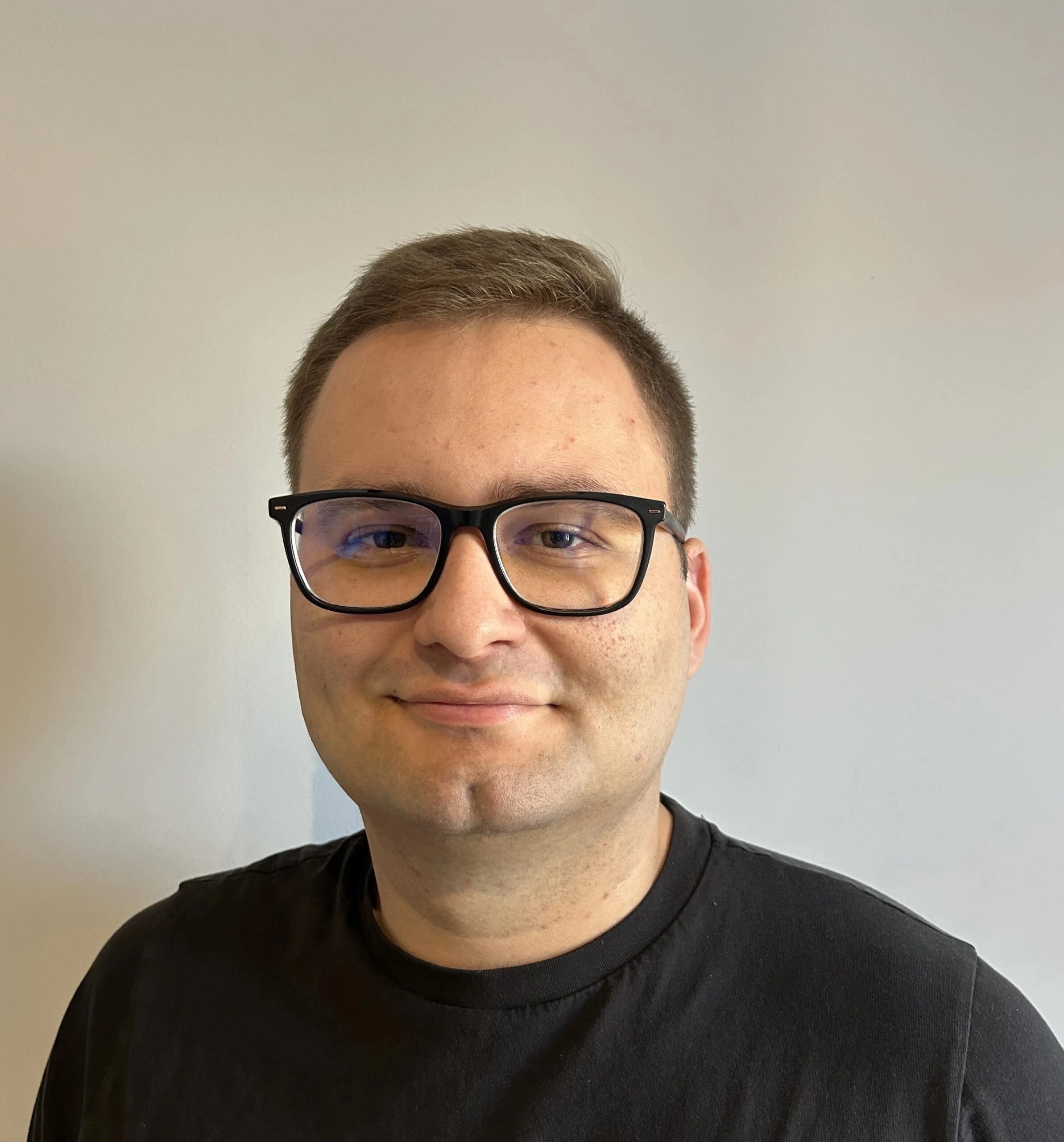 Księgowy Mateusz Marcinkowski przy biurku przegląda uporządkowane dokumenty księgowe z laptopem i kalkulatorem, przygotowując raporty finansowe i rozliczenia podatkowe